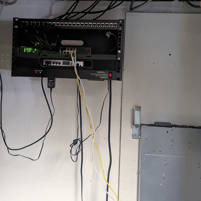 Wall-mounted network patch panel and switch installation